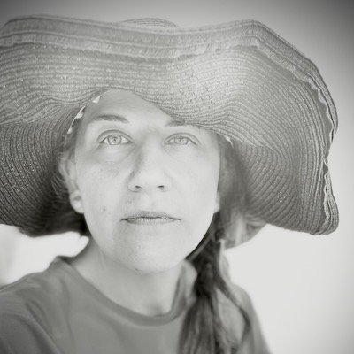 black and white photograph of Elizabeth Lorang wearing a wide-brimmed sunhat and looking at the camera